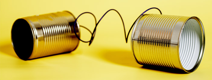 two tin cans laying on sides connected by a wire
